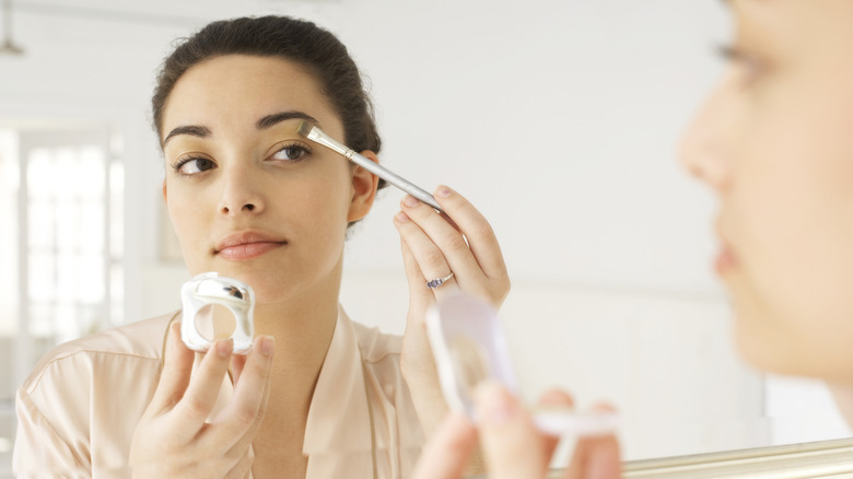 woman putting on makeup