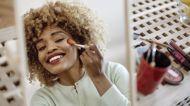 woman putting on makeup