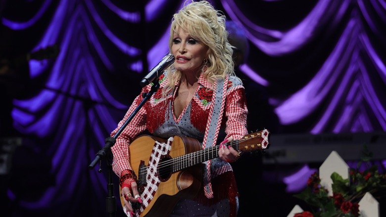 Dolly Parton playing guitar on stage