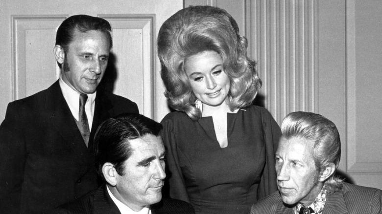 Black-and-white photo showing Dolly Parton standing with three men in 1968 while wearing a huge wig
