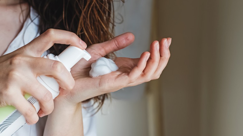 Woman putting mousse in hand