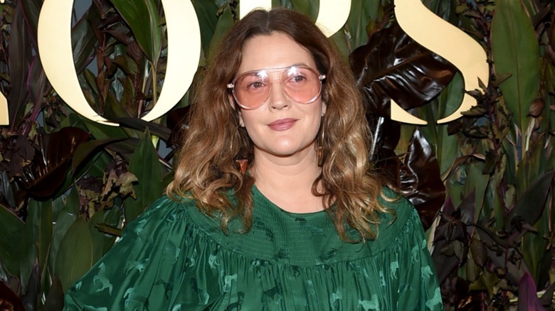 Drew Barrymore in a green dress and oversized pink glasses on the red carpet in 2019
