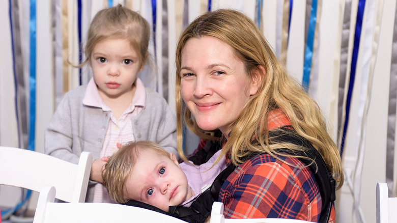Drew Barrymore posing with her young daughters Olive and Frankie at a 2014 event