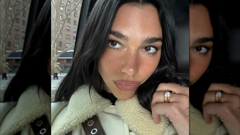 A selfie of Dua Lipa in the car showing her engagement ring