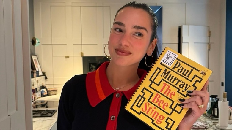 Dua Lipa holding The Bee Sting by Paul Murray