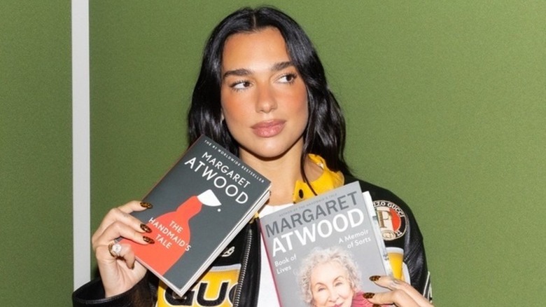Dua Lipa holding The Handmaid's Tale by Margaret Atwood