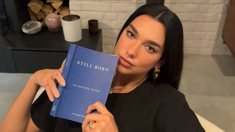 Dua Lipa holding Still Born by Guadalupe Nettel