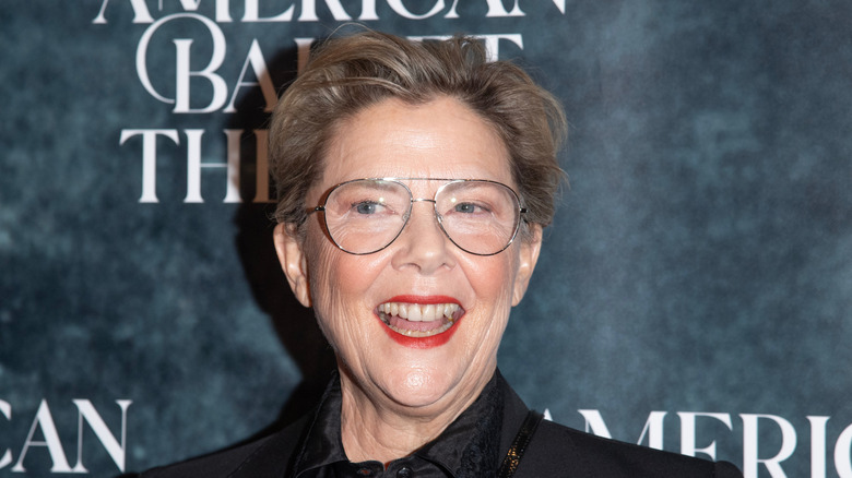 Annette Bening wearing aviator glasses and red lipstick