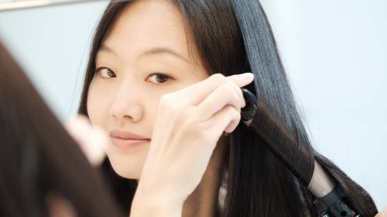 woman curling silky hair