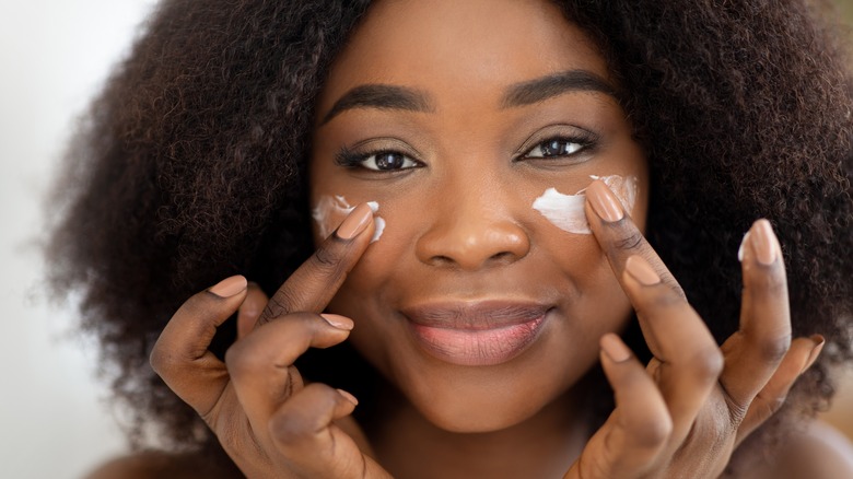 Woman putting on facial cream