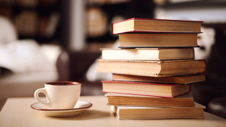 Stack of books next to a cup and plate