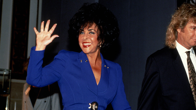 Elizabeth Taylor waving while walking with husband Larry Fortensky in 1991
