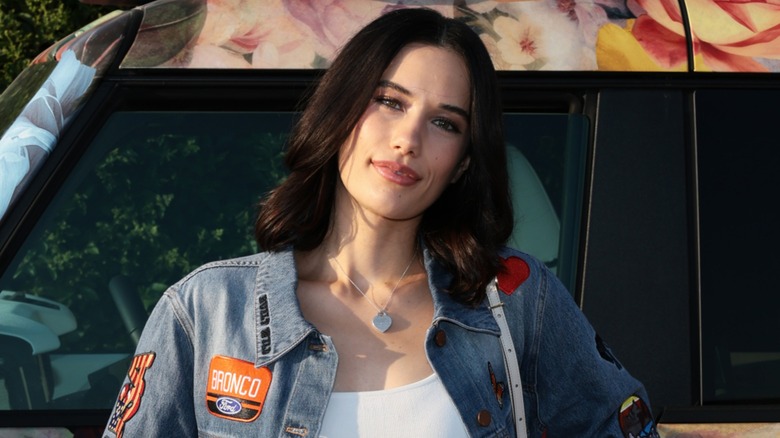 Ella Bleu Travolta smiling in a denim jacket