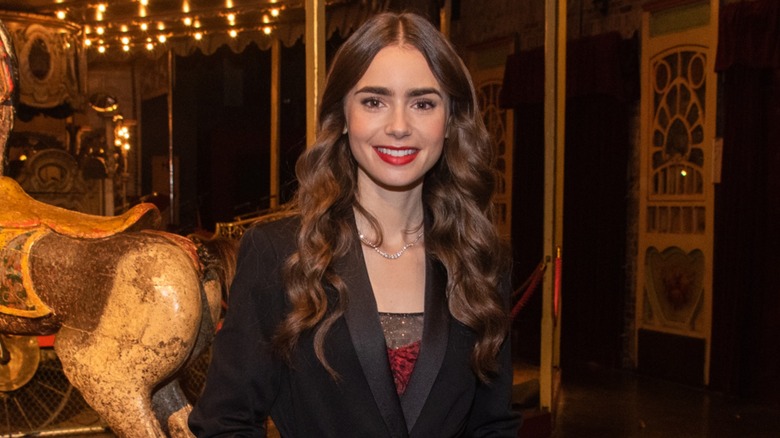 Lily Collins posing on the Emily In Paris set