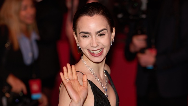 Lily Collins waving on the red carpet