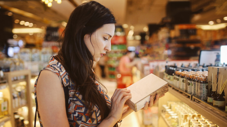 Woman looks at moisturizers in store