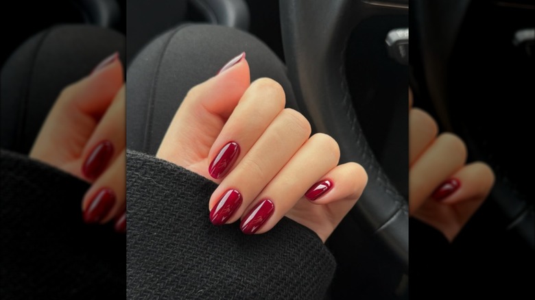 A hand with deep red nails