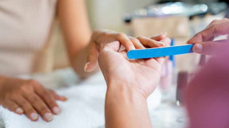 A woman getting her nails filed at the nail salon