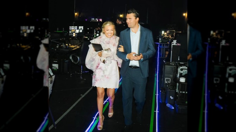 Erika and Charlie Kirk linking arms at an event