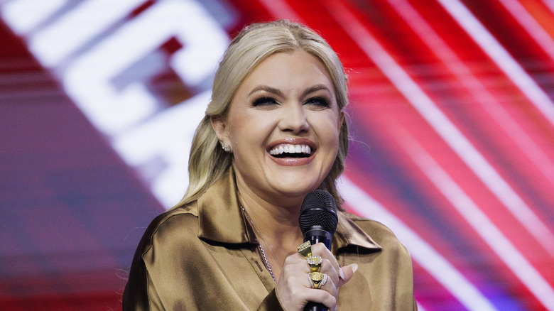 Erika Kirk on stage, laughing into a microphone