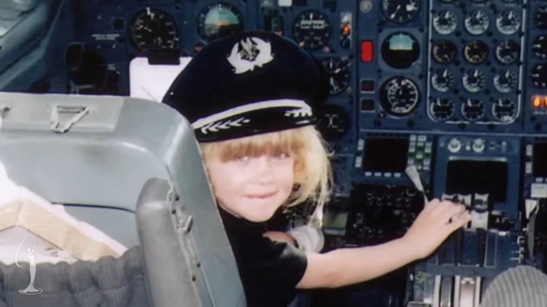 Young Erica Kirk in an airplane cockpit