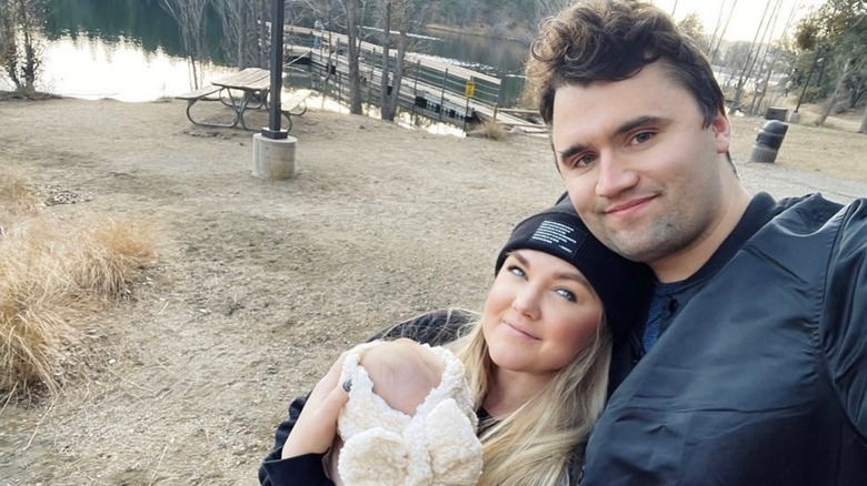 Erika Kirk and Charlie Kirk posing with their daughter