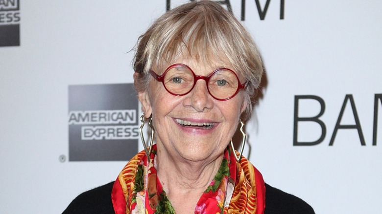 Estelle Parsons smiling while posing on the red carpet in front of a black-and-white background in 2011