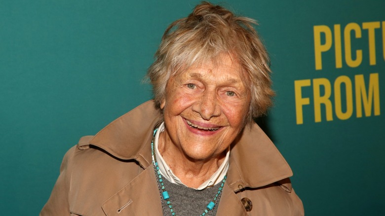 Estelle Parsons smiling on the red carpet in front of a green background