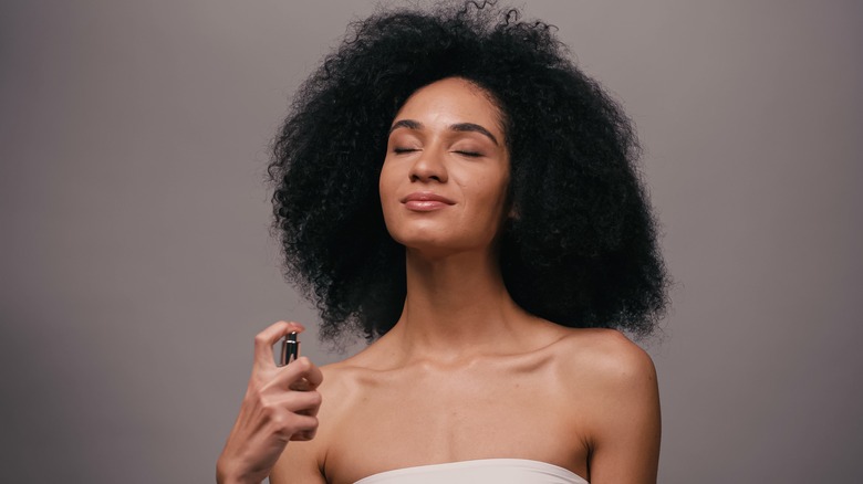 Woman applying perfume 