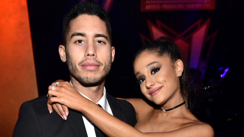 Ricky Alvarez and Ariana Grande posing for a photo, Grande's arms wrapped around Alvarez