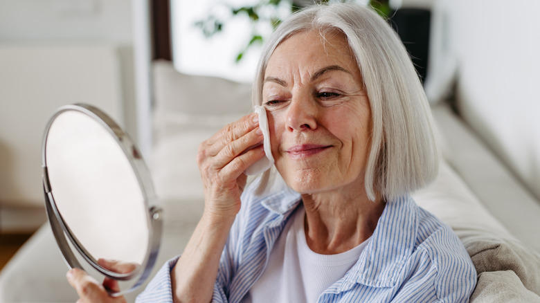 Mature woman prepping her skin for makeup