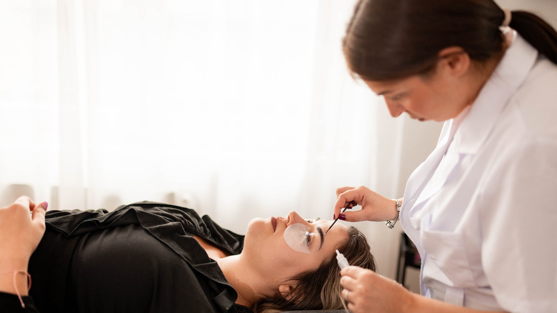Women getting her eyebrows tinted by an expert