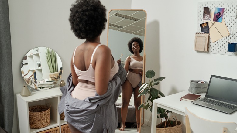 Woman looking at body in mirror