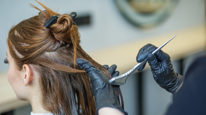 A young woman getting her hair dyed at a salon