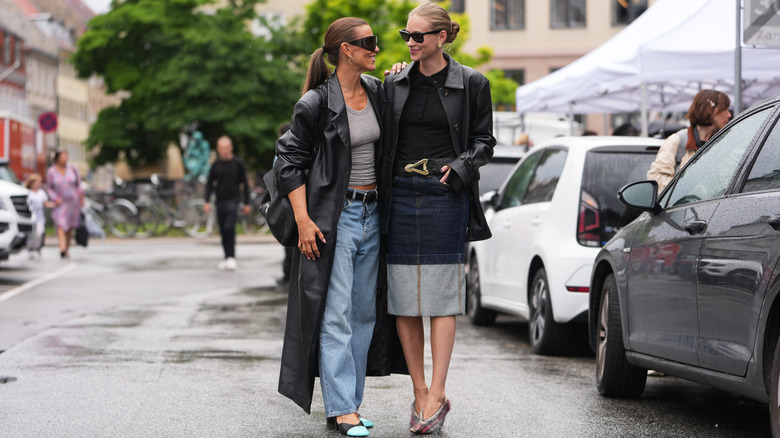 Two women in the street wearing denim and leather outfits