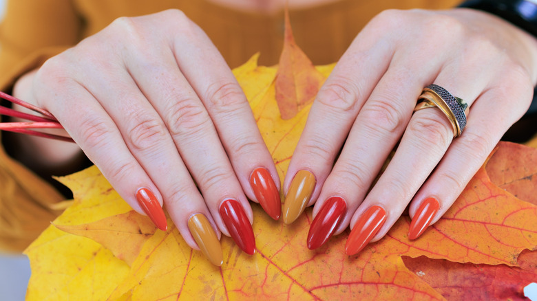 Woman with almond nails holding leaves