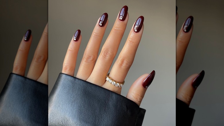 A woman shows off her burgundy manicure.