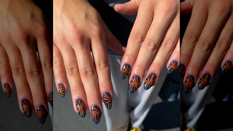 A woman showing off her manicure with zebra stripes.