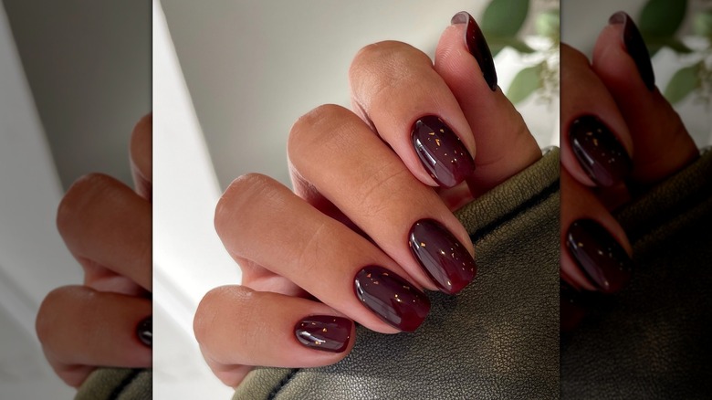 Nail artist shows off her burgundy manicure.