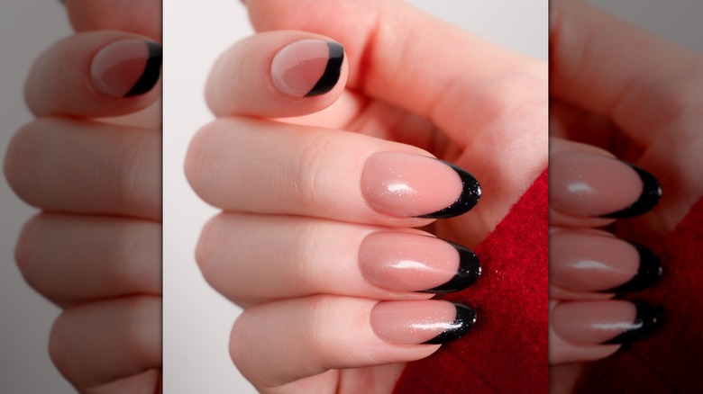 A woman with a dark French manicure