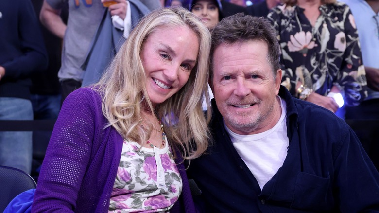 Tracy Pollan smiling and posing with her head against her husband Michael J Fox's