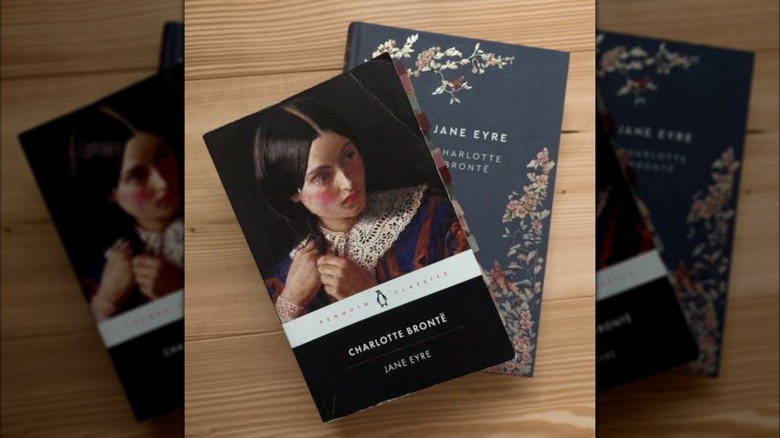 Two different editions of the book Jane Eyre on a wooden table