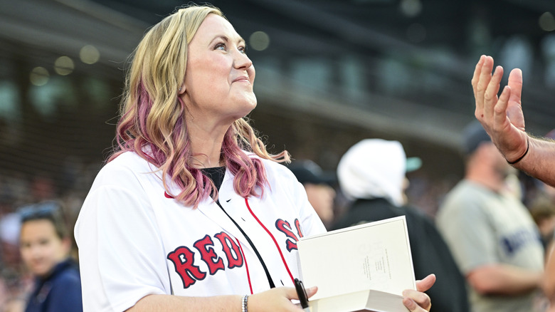Rebecca Yarros signs autographed copies of "Fourth Wing" prior to a game between the Cleveland Guardians and Boston Red Sox at Fenway Park on September 03, 2025