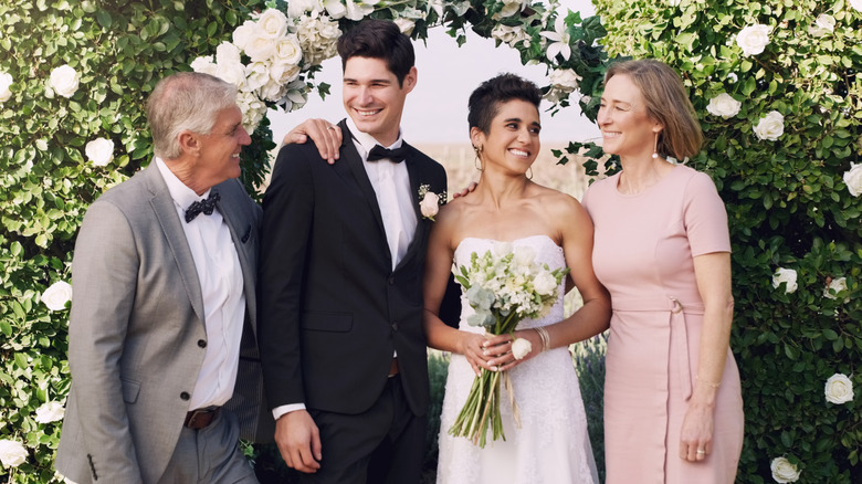 A bride and groom with his parents on their wedding day