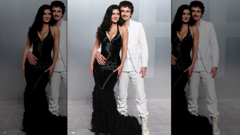 Kylie Jenner wearing a black fishtail gown and Timothée Chalamet wearing an all-white suit