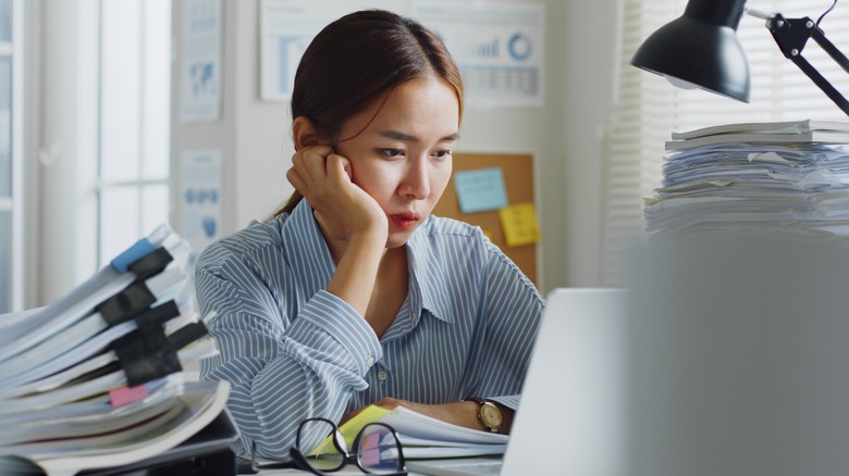 A woman looking upset sitting at a desk