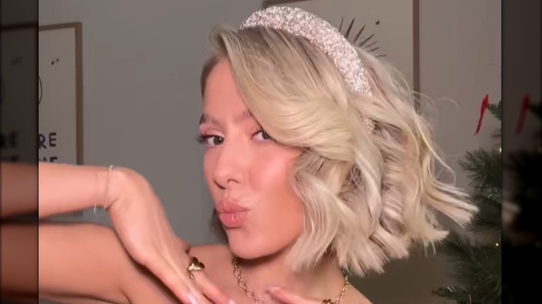 A woman with a curly hair and a sparkly headband