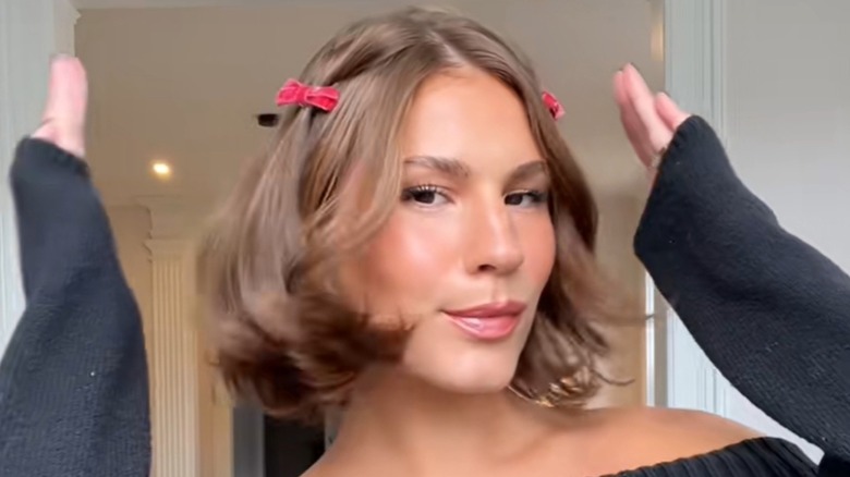 A woman with a bob and two bows in her hair