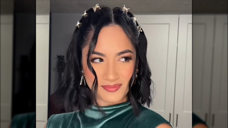 A woman with a bob and several clips in her hair