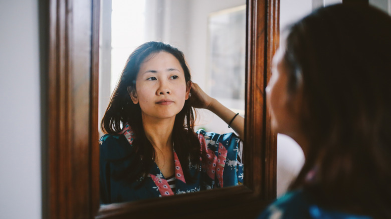 Woman looking into mirror